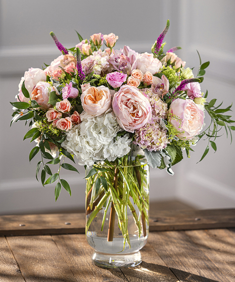 Grand Splendor Vase Arrangement featuring peonies, roses, hydrangea and favorite garden flowers in a tall pedestal vase.