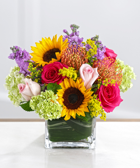 The Countryside Garden Bouquet features Sunflowers, Lilies, Roses, and Hot Pink Gerbera Daisies